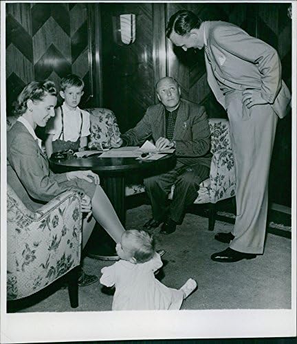 Гроздобер фотографија на семејството L.M. Ericson39 со нивните трудови на маса што ја разгледува полицијата за пасош во Гетеборг.Такен - август 1943 година