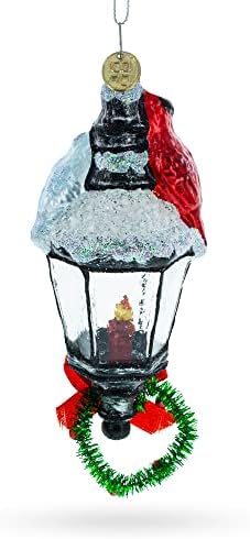 Црвен кардинал што седеше на снежен стакло на фенер, Божиќниот украс