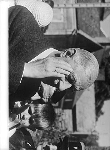 Гроздобер фотографија на Чарлс де Гол го допира лицето.